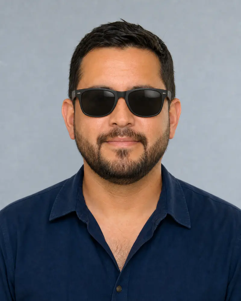 Same man wearing matte black wayfarer-style sunglasses with charcoal lenses