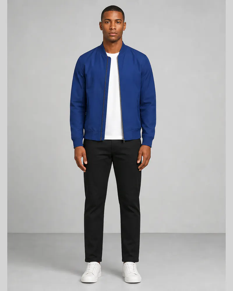 Same man wearing a cobalt bomber jacket and black trousers after AI clothes try-on
