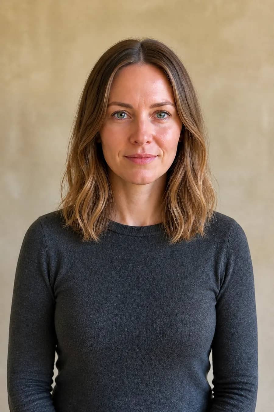 Same woman with a collarbone-length layered dark-blonde lob after an AI haircut preview