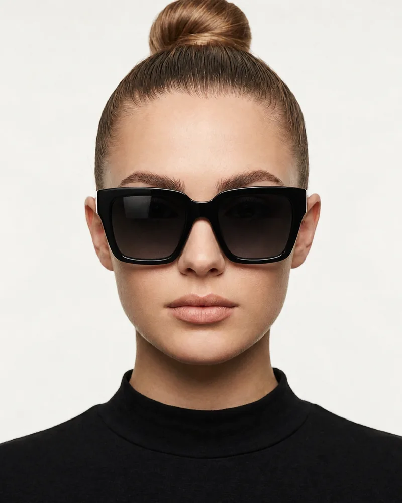 Same woman wearing oversized black square sunglasses with dark gradient lenses