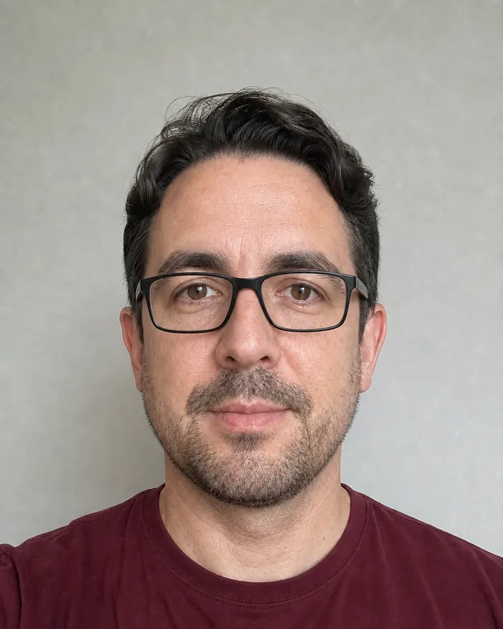 Same front-facing man wearing centered matte-black rectangular glasses after AI try-on